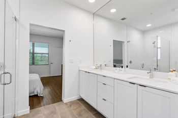 A white bathroom with two sinks and a mirror